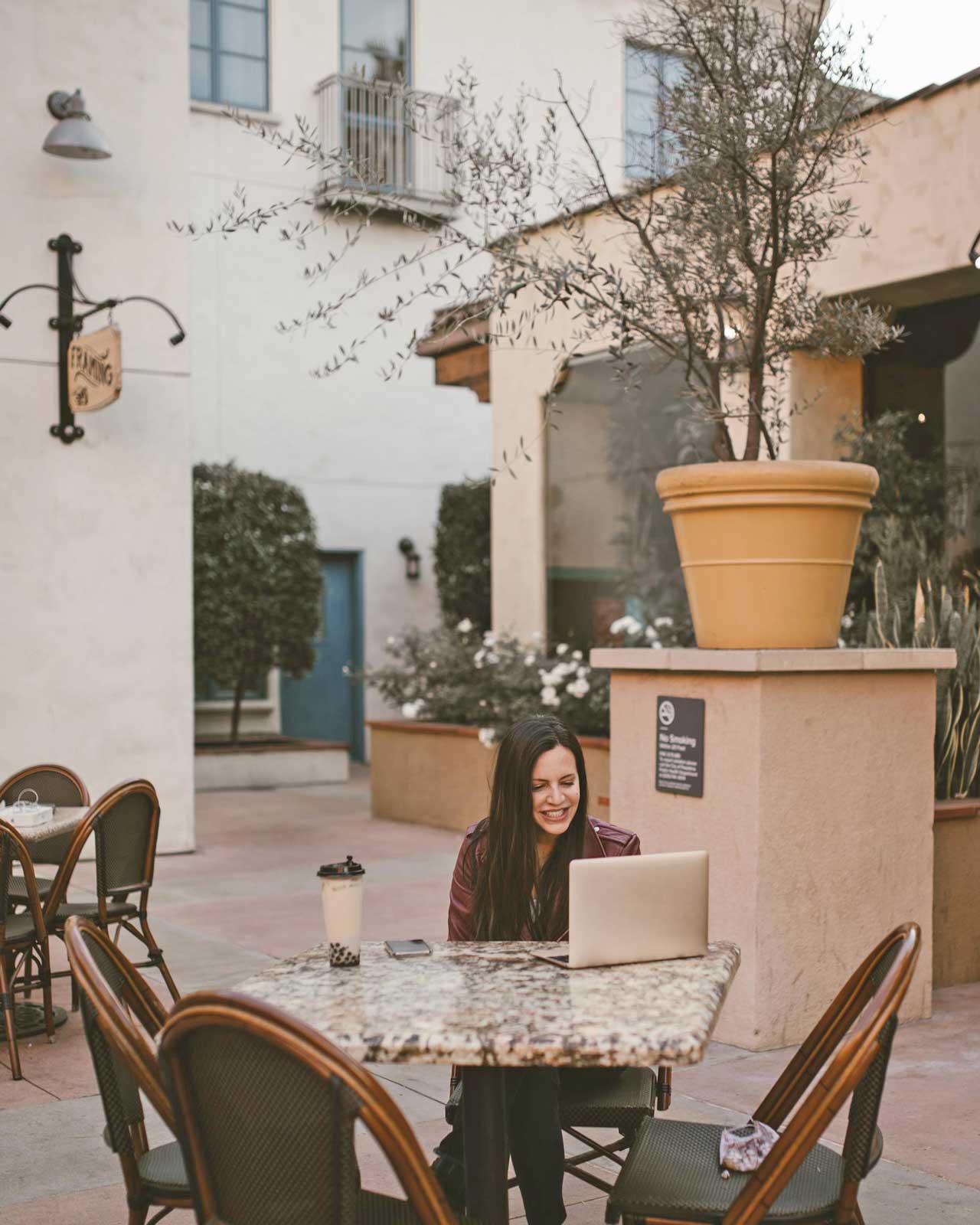 Woman working outdoors at a cafe | Career Freedom